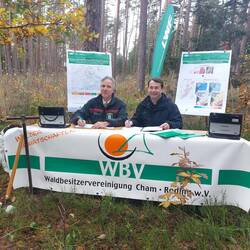 Zwei Personen unterschreiben im Wald ein Dokument